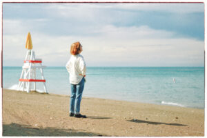 Woman standing at the beach, looking out over the waves, and her unexpected future.