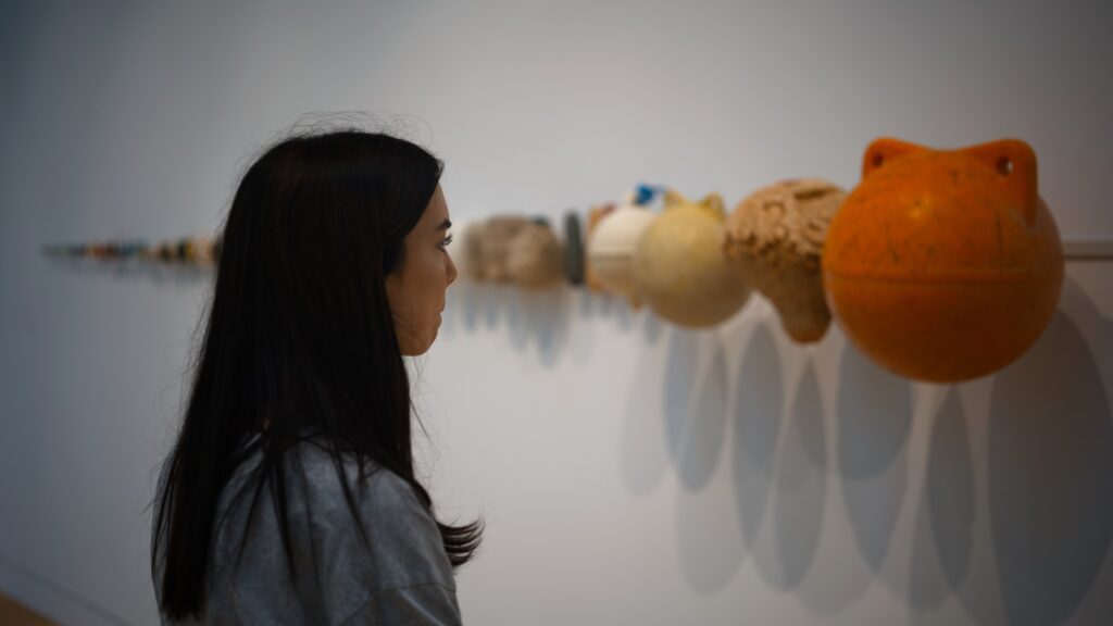 Marissa contemplating "Economies of Scale, 2013 - Economies of Scale is a metaphorical timeline"